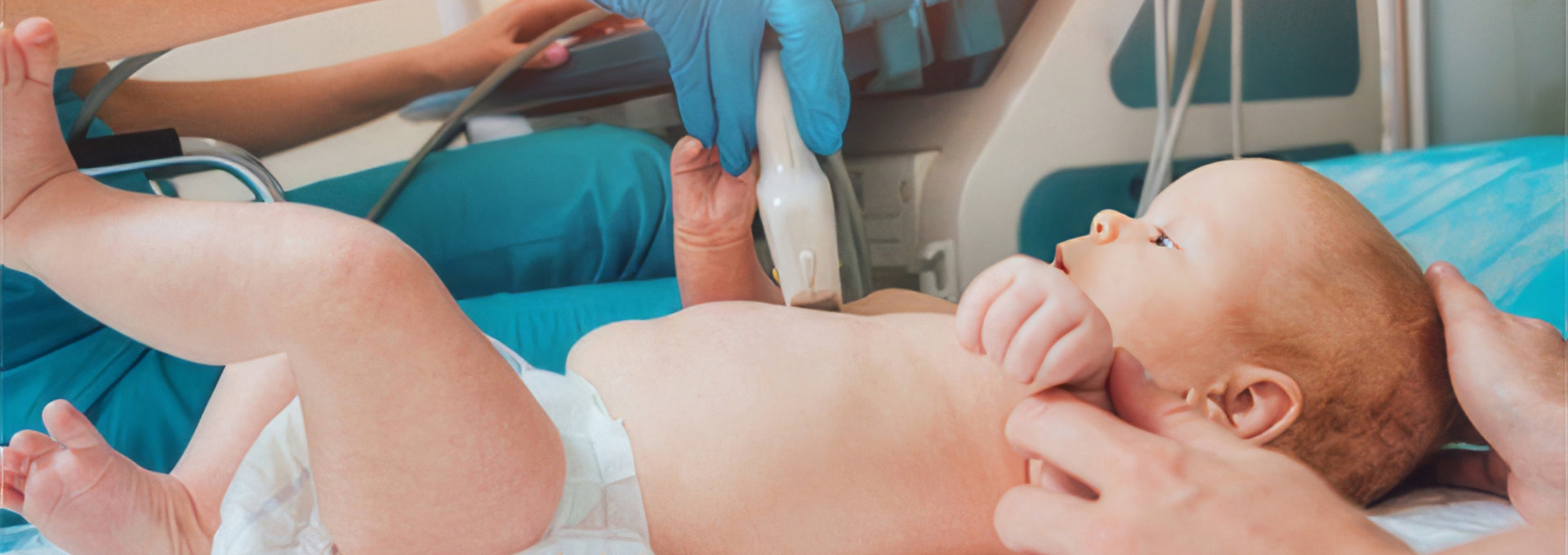 Ein Baby liegt auf einem Untersuchungstisch in einer Arztpraxis oder einem Krankenhaus. Eine Person trägt blaue Einweghandschuhe und führt mit einem Ultraschallgerät eine Untersuchung am Bauch des Babys durch. Das Baby trägt eine Windel und hält die Beine leicht angehoben. Eine weitere Hand hält das Baby sanft am Arm, um es zu beruhigen und zu stabilisieren. Im Hintergrund sind medizinische Geräte sichtbar. Die Szene deutet auf eine medizinische Untersuchung hin, vermutlich zur Überprüfung der inneren Organe oder zur Diagnose von gesundheitlichen Problemen.