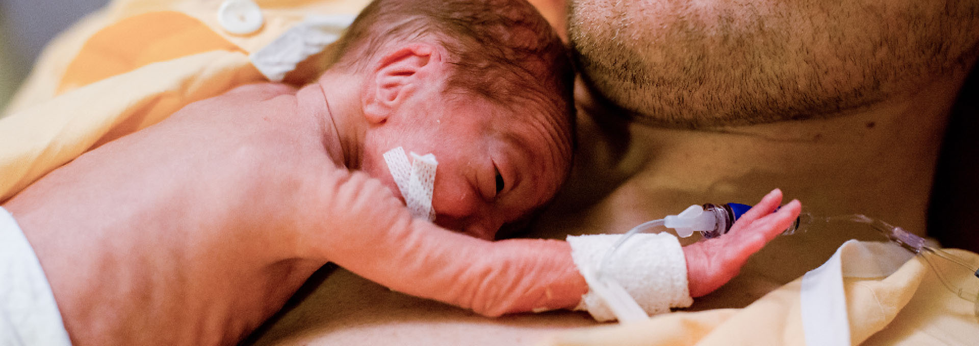 Ein Baby liegt auf einer männlichen Brust