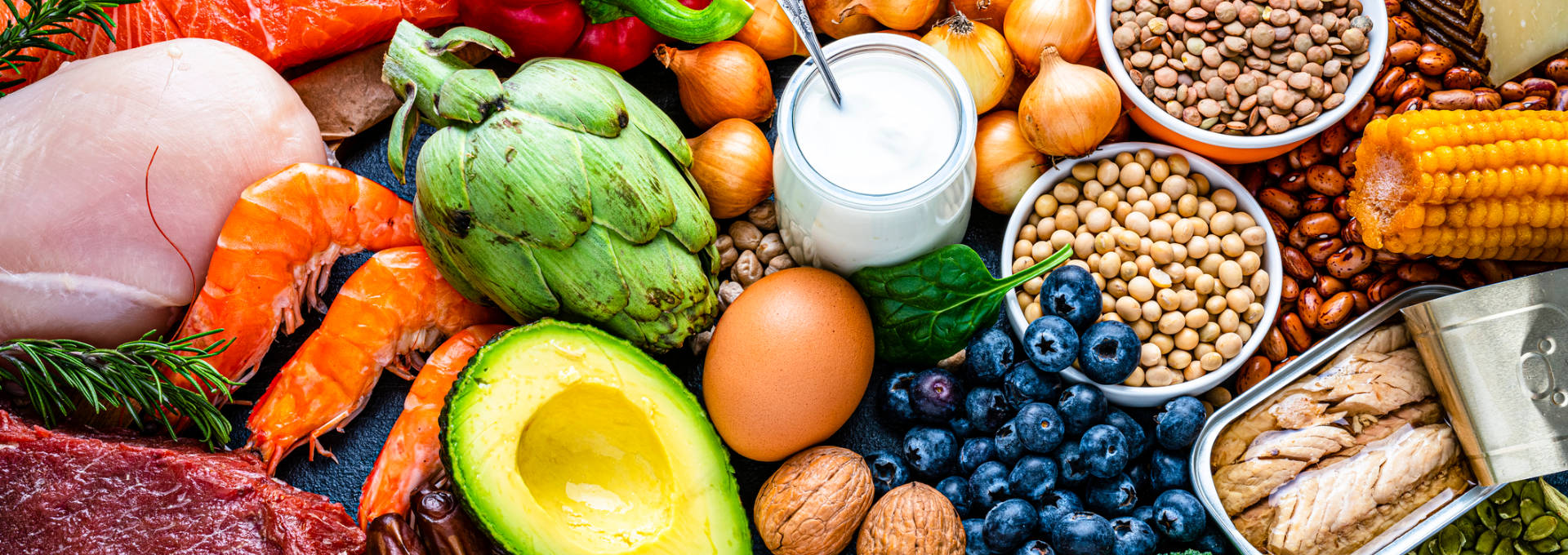Viele bunte und gesunde Lebensmittel – von Heidelbeeren, Linsen und Joghurt bis hin zu Brokkoli, Öl, Kernen und Fleisch