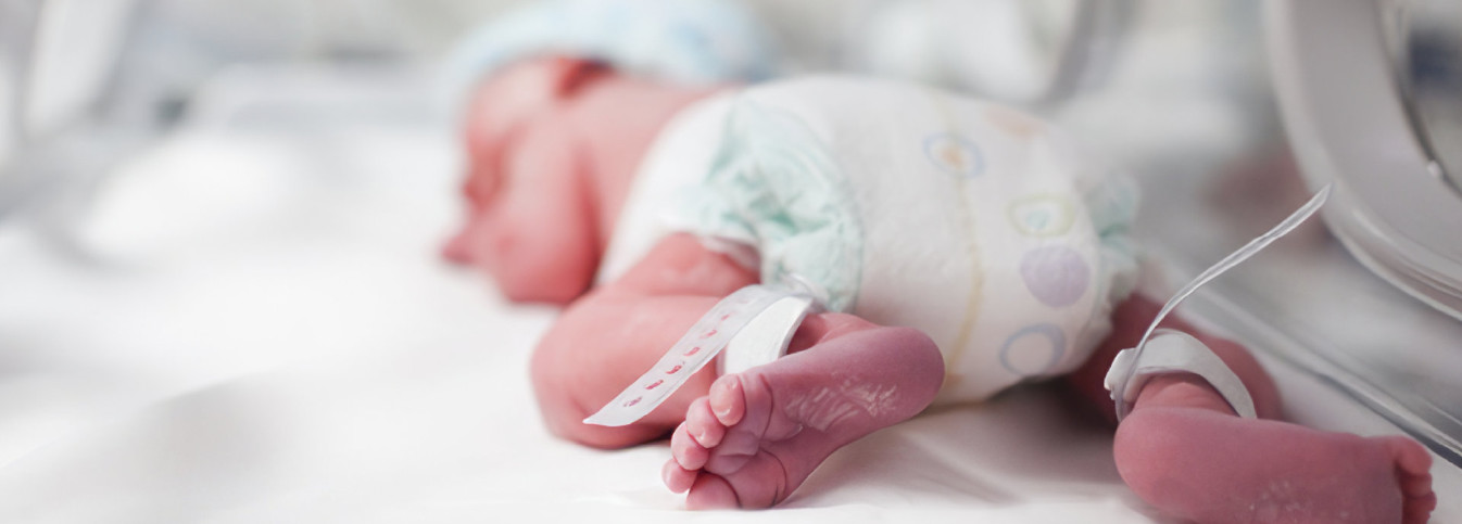 ein Neugeborenes in einem Krankenhausbett