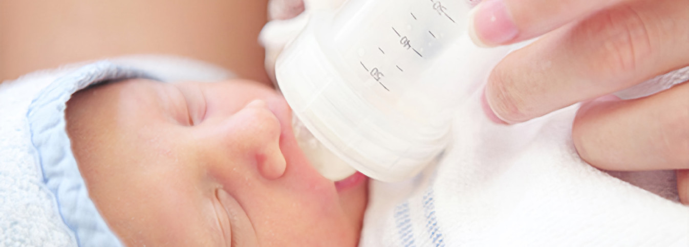 ein Baby, das aus einer Flasche trinkt