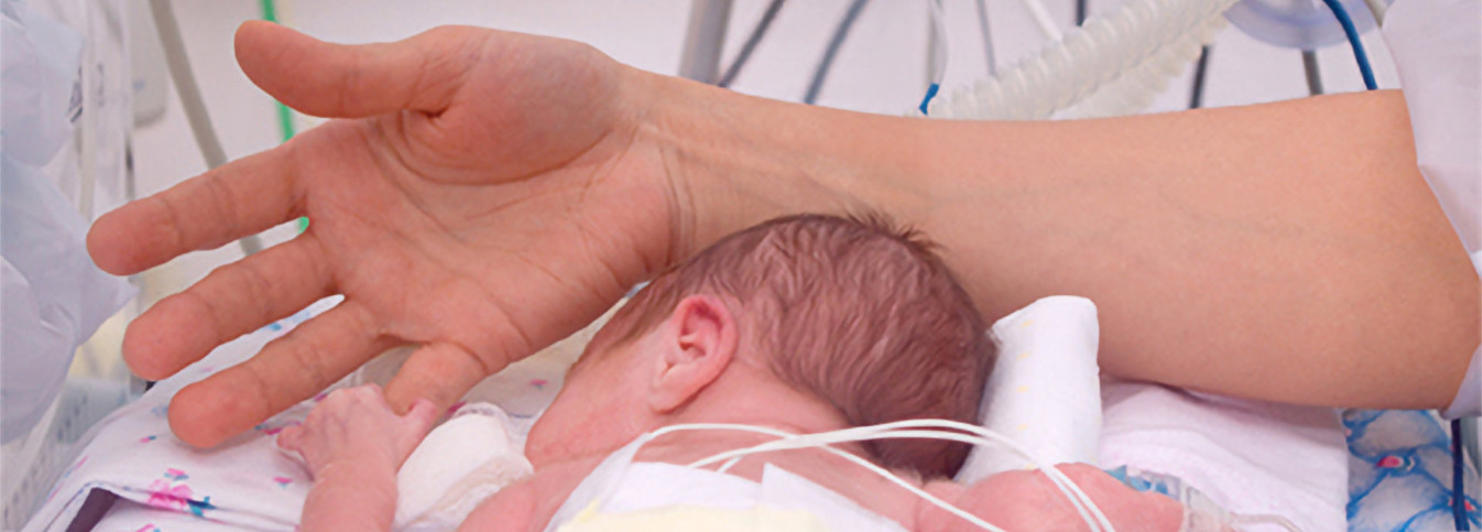 eine Hand, die ein Baby hält
