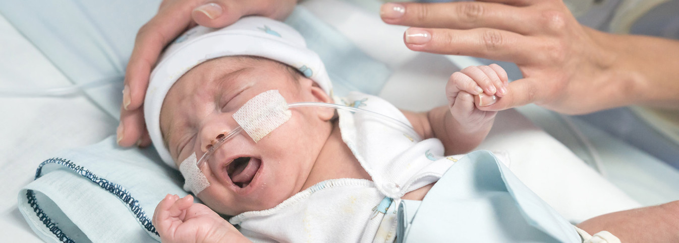 ein Baby mit einem Schlauch im Mund