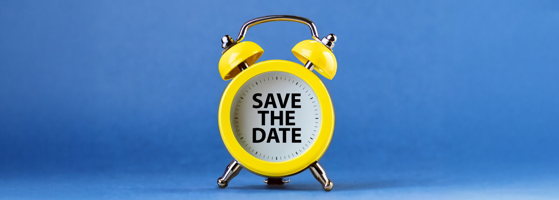 Gelber Wecker mit Schriftzug "Save the Date"